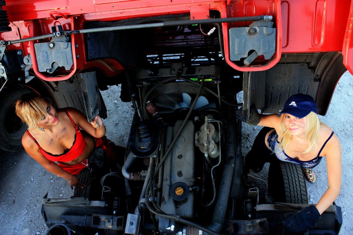 Девушка чинит КАМАЗ