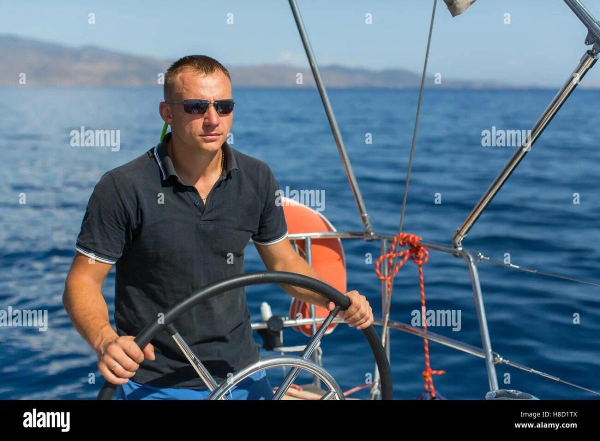 Мужчина за штурвалом яхты