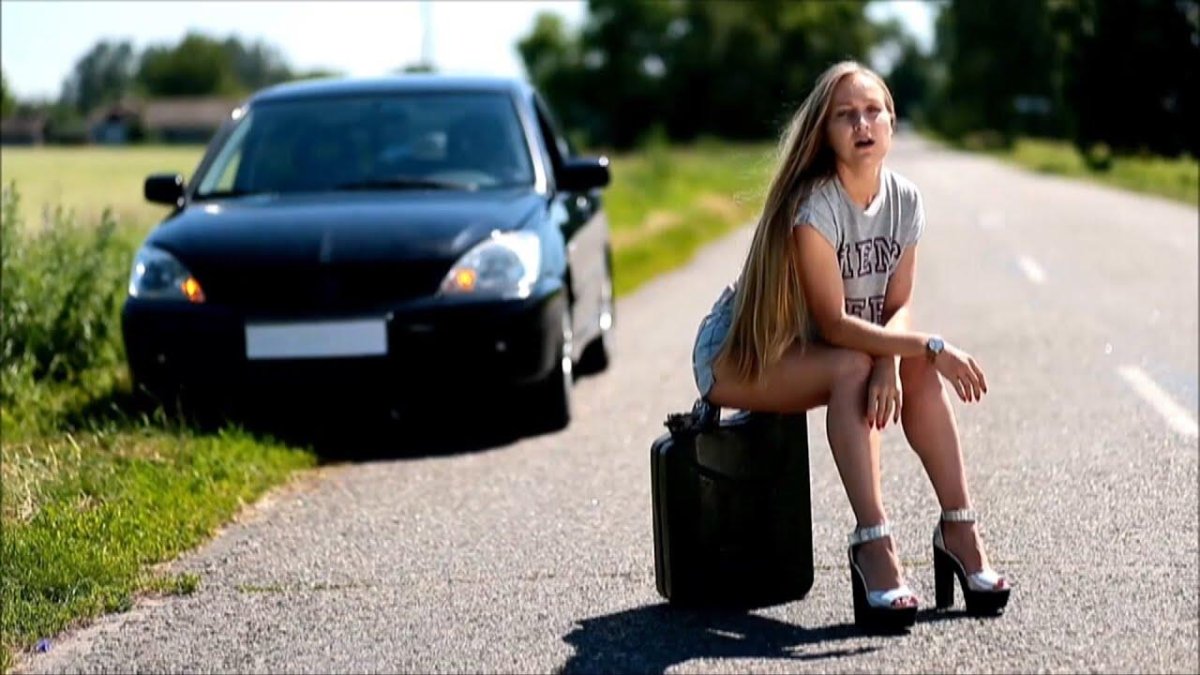 Девушка сидит на дороге