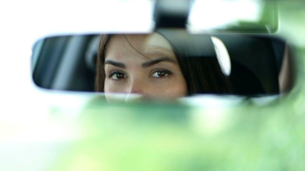 Глаза девушки в зеркале заднего вида