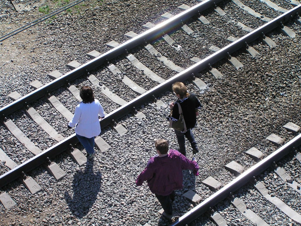 Люди переходят железную дорогу