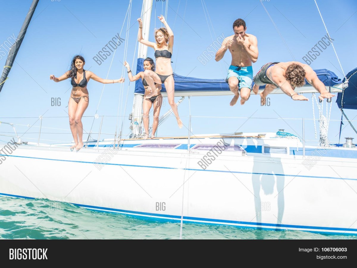 Люди прыгают с яхты