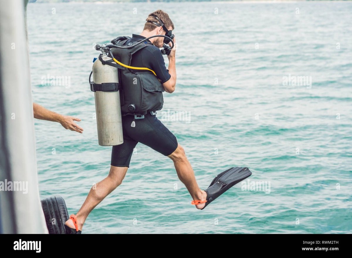 Аквалангист погружается с лодки