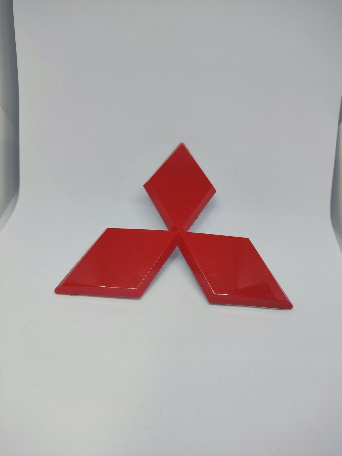 Красная эмблема Митсубиси Лансер 10