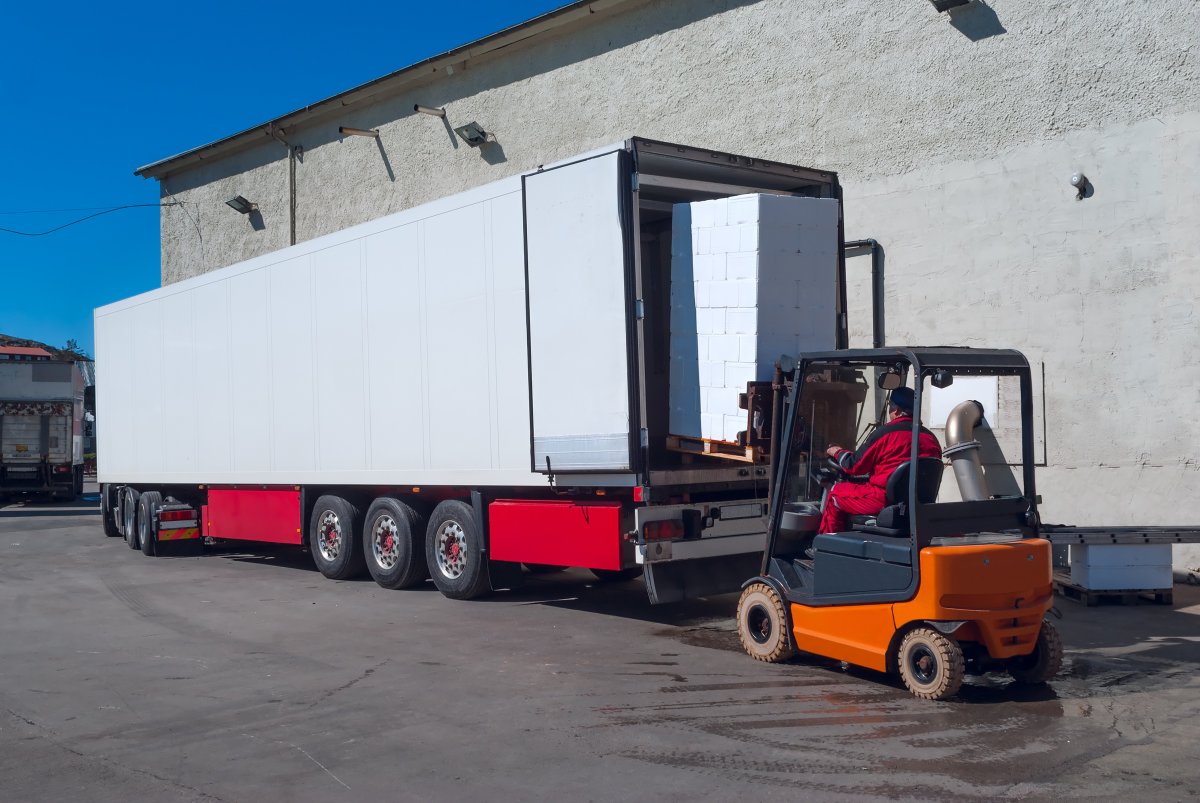 Погрузчик грузит фуру