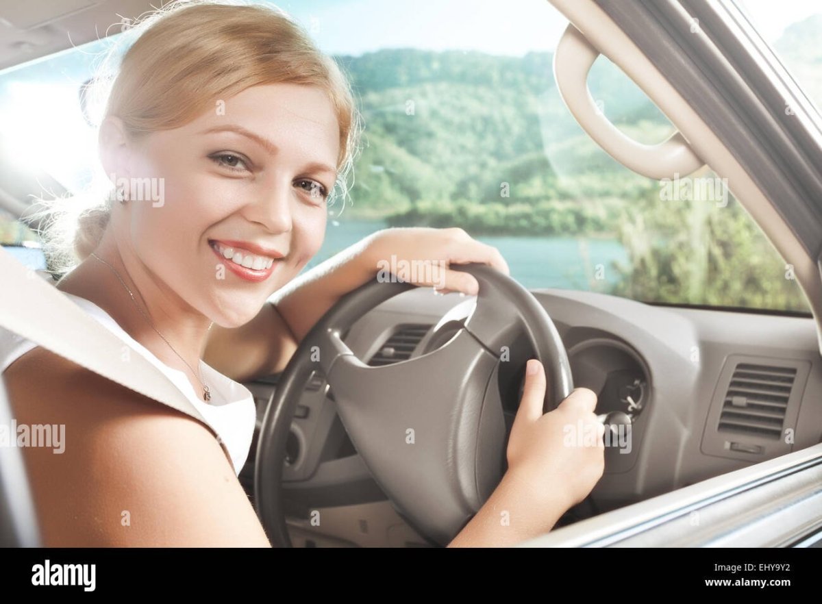Девушка за рулем улыбается