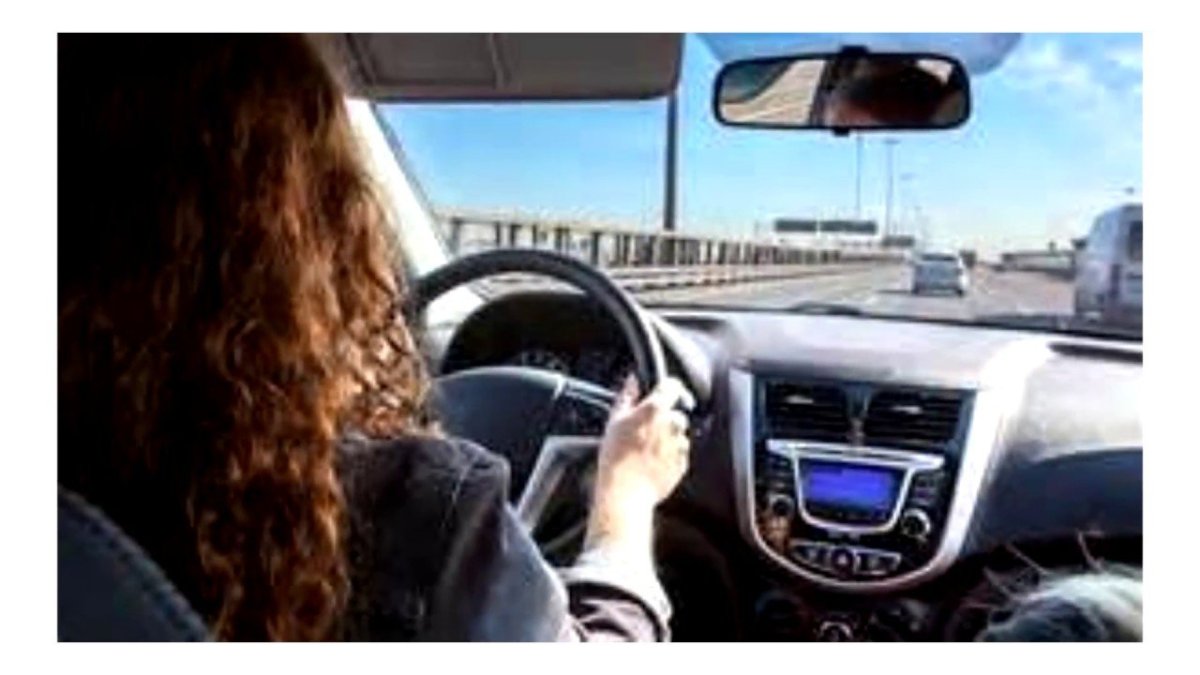 Кудрявая девушка за рулем