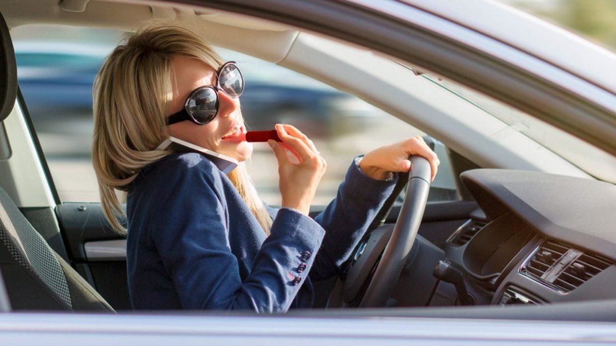 Женщина за рулем с телефоном